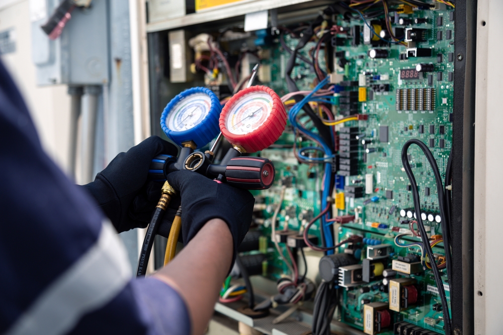 Air conditioning, HVAC service technician using gauges to check refrigerant and add refrigerant,Air Conditioning Repair, repairman on the floor fixing air conditioning system.
