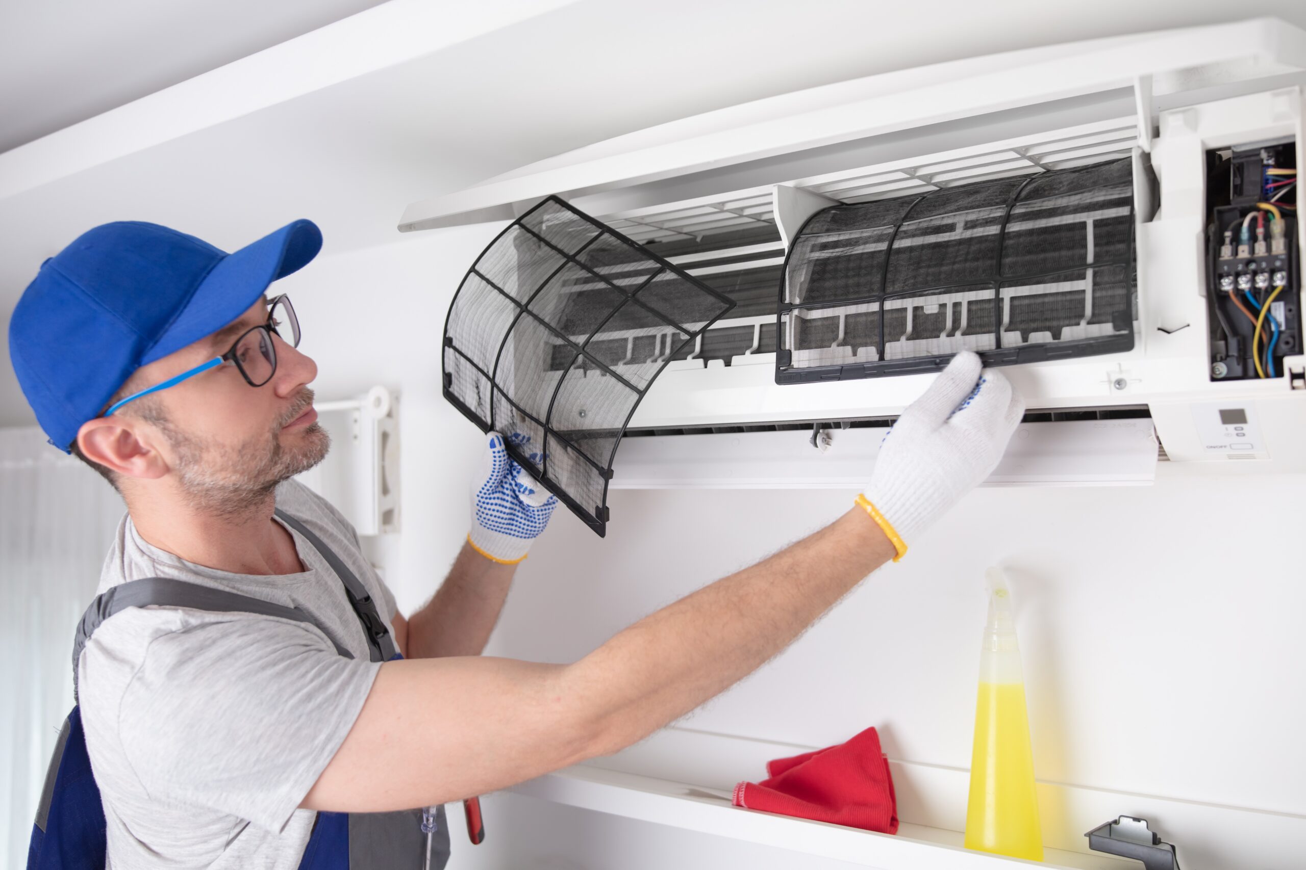 Service guy cleaning and maintaining air condition unit.
