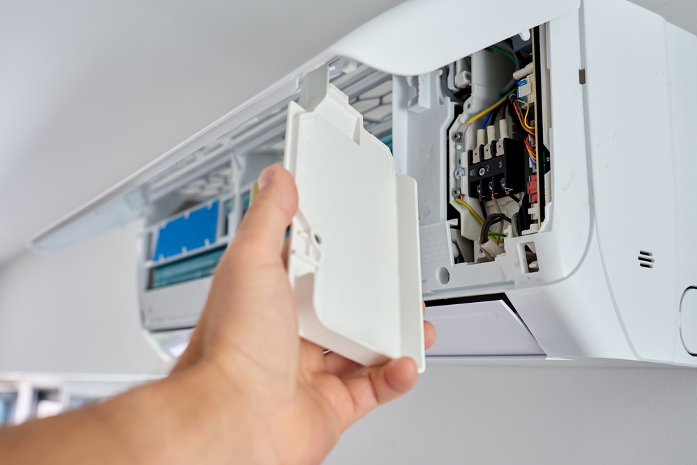 Hand opens the cover of a wall air conditioner