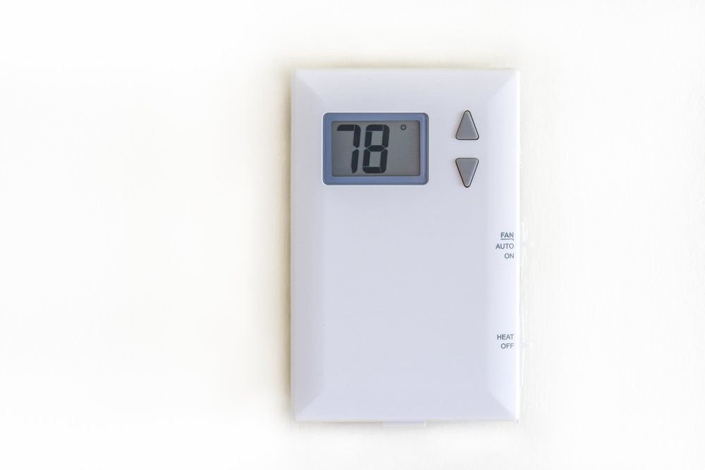 White digital thermostat on antique white wall